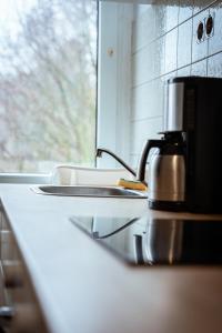 a kitchen counter with a sink and a coffee maker at Wohnung am See in Wetter +31 photos
