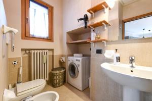 a bathroom with a sink and a washing machine at Central Square in Sirmione +20 photos