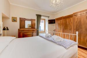 a bedroom with a large white bed with towels on it at Central Square in Sirmione