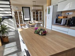 a kitchen with a wooden table with flowers on it at Lakeforest Dedinky Wellness Chata privát jacuzzi aj sauna, výhľad na jazero in Dedinky