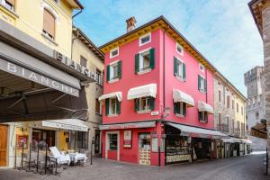 a pink building on the side of a street at Central Square in Sirmione