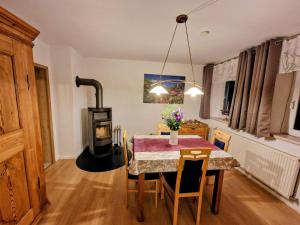 a dining room with a table and a wood stove at Haus am Thiesenring in Bad Berneck im Fichtelgebirge
