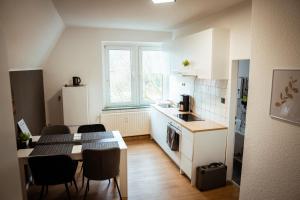 a kitchen with a table and chairs and a kitchen with a table and a kitchen at Wohnung am See in Wetter