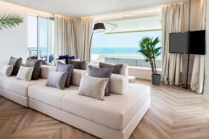 a living room with a white couch and a large window at Hotel Corallo in Riccione