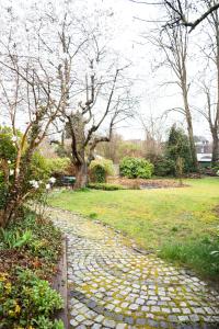 a cobblestone walk way in a park with trees at Wohnung am See in Wetter