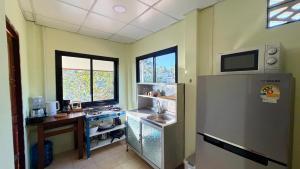 a kitchen with a refrigerator and a sink in it at Chill House in Ko Phangan