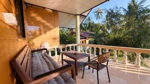 a balcony with a couch and a table and chairs at Chill House in Ko Phangan