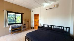 a bedroom with a bed and a window at Chill House in Ko Phangan