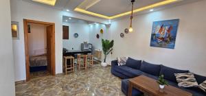 a living room with a blue couch and a table at Padova Surf Hous in Imsouane +45 photos