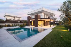 a house with a swimming pool in front of it at NNV Pool Villa Lazise in Lazise
