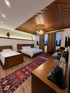 a large room with two beds and a table at Castle Hotel in Gjirokastër