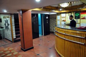 a man standing at a bar in a restaurant at Brightland Hotel near Mall Road - Stags entry not allowed in Shimla