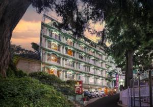 a large building on a street with a tree at Brightland Hotel near Mall Road - Stags entry not allowed in Shimla