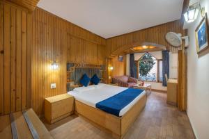 a bedroom with a bed in a room with wooden walls at Brightland Hotel near Mall Road - Stags entry not allowed in Shimla +53 photos