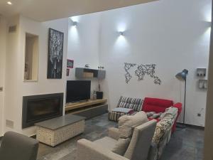a living room with a couch and a tv at Casa Solaria Córdoba in Guadalcázar