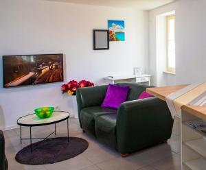 a living room with a green couch and a table at DeLuxe Afrodita Apartment in Rovinj