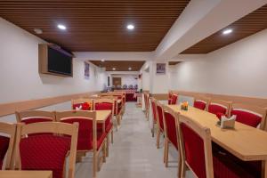 a dining room with wooden tables and red chairs at Brightland Hotel near Mall Road - Stags entry not allowed in Shimla
