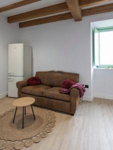 a living room with a brown couch and a table at El Sueño, Paca in Barres