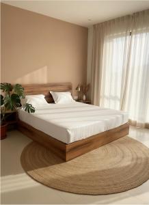 a bedroom with a large bed with a large window at Backwoods inn in Heggadadevankote