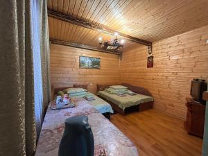 a room with two beds in a log cabin at Садиба У Коса in Pilipets