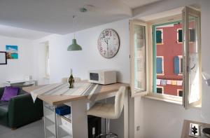 a kitchen with a table and a clock on the wall at DeLuxe Afrodita Apartment in Rovinj