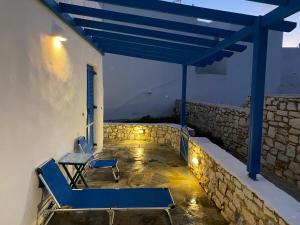 a blue bench and a table on a patio at Villa Effie in Aspro Chorio Paros