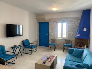 a living room with a blue couch and chairs at Villa Effie in Aspro Chorio Paros