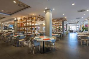 a restaurant with tables and chairs in a library at Abora Continental by Lopesan Hotels in Playa del Ingles