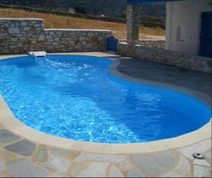 a large pool with blue water in a yard at Villa Effie in Aspro Chorio Paros