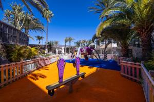 a playground with a slide in a park with palm trees at Abora Continental by Lopesan Hotels in Playa del Ingles