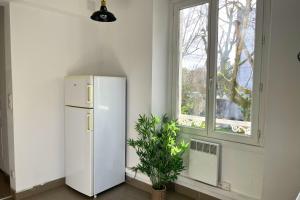 a white refrigerator in a room with a window at L'Éclipse - Gare de Melun in Melun