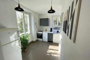 a kitchen with white appliances and two windows at L'Éclipse - Gare de Melun in Melun