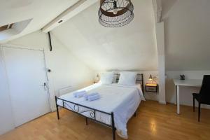 a bedroom with a bed with white sheets and a chandelier at L'Éclipse - Gare de Melun in Melun