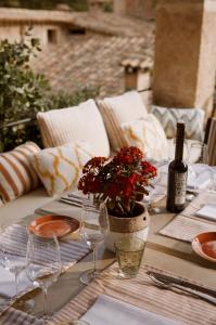 a table with wine glasses and red flowers on it at La Residencia, A Belmond Hotel, Mallorca in Deia