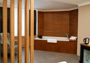 a bathroom with a bath tub with wooden walls at ERSA Hotel in Tuzla +23 photos