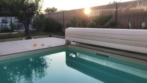 a swimming pool with a bench in the water at Chambre paisible in Albi