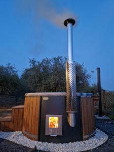 a outdoor stove with a fire in a backyard at Koru Etna Glamping - lodge con vasca idromassaggio privata in Ragalna