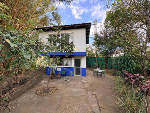 a white and blue house with a tree in front of it at Rainforest Cabin in Escazu in Escazu +28 photos
