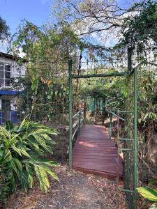 a wooden bridge with a wooden walkway in a garden at Rainforest Cabin in Escazu in Escazu