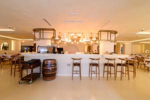 a bar in a restaurant with bar stools at Iconic Mediterranean Hotel in Dhërmi
