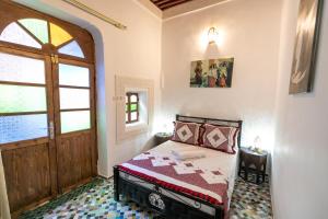 a bedroom with a bed and a window and a door at Dar El Kendil in Fez