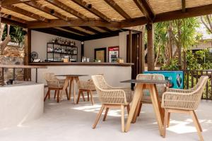 a patio with tables and chairs and a bar at Casa Elounda - Adults only Hotel "by Checkin" in Agios Nikolaos