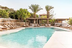 a swimming pool with chairs and a gazebo at Casa Elounda - Adults only Hotel "by Checkin" in Agios Nikolaos