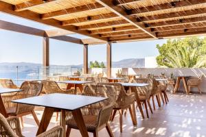 a restaurant with tables and chairs on the roof at Casa Elounda - Adults only Hotel "by Checkin" in Agios Nikolaos