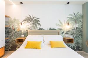 a bedroom with a large white bed with yellow pillows at Alexandra B&B & Brunch -Beach Front Parking Included in Misano Adriatico