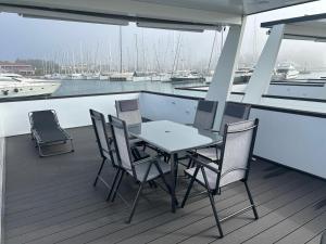 a table and chairs on the deck of a boat at Hausboot Santa Lucia Novigrad - Floating Sea House in Novigrad Istria