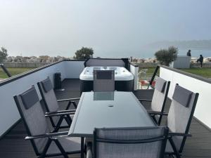 a table and chairs on a balcony with the ocean at Hausboot Santa Lucia Novigrad - Floating Sea House in Novigrad Istria