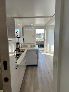 a kitchen with white cabinets and a wooden floor at Hausboot Santa Lucia Novigrad - Floating Sea House in Novigrad Istria