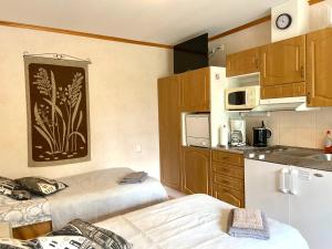 a small kitchen with two beds in a room at Yli-Kaitala Holiday Resort Tuuliviiri in Savio