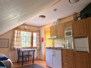 a kitchen with a white refrigerator and a table with chairs at Yli-Kaitala Holiday Resort Tuuliviiri in Savio
